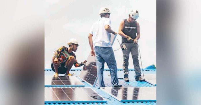 doe Members of environmental groups help residents of Barangay Coring, Basilisa, Dinagat Islands install solar panels in their barangay gymnasium. JILSON TIU/GREENPEACE FILE PHOTO