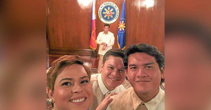duterte The Duterte siblings, Sara, Paolo, and Sebastian, take a selfie with their father in the background during President Rodrigo Duterte’s oath-taking on June 30, 2016. PHILIPPINE DAILY INQUIRER PHOTO