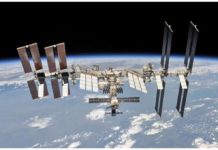 The International Space Station photographed by an astronaut with Earth in the background. It has a long reflective surface with lots of solar panels sticking out from it. REUTERS