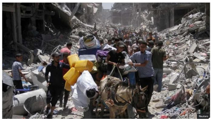 A group of Palestinians walk surrounded by destroyed buildings in the war-torn Gaza Strip. REUTERS