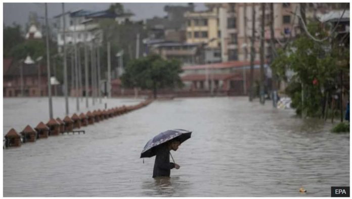Asia_resized A person wades through a flooded street caused by the swollen Bagmati River after torrential rains in Kathmandu, Nepal on July 6, 2024. Streets in the Nepalese capital Kathmandu were flooded over the weekend from overflowing rivers. EPA