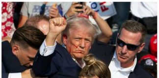 Despite his wounded ear, former US President Donald Trump – while being quickly covered by his Secret Service – still managed to pump his fist in the air and shout, “Fight! Fight! Fight!” Streaks of blood can be seen on his face. BBC