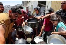 Palestinians wait to receive food at a charity kitchen in Khan Younis, in the southern Gaza Strip. REUTERS