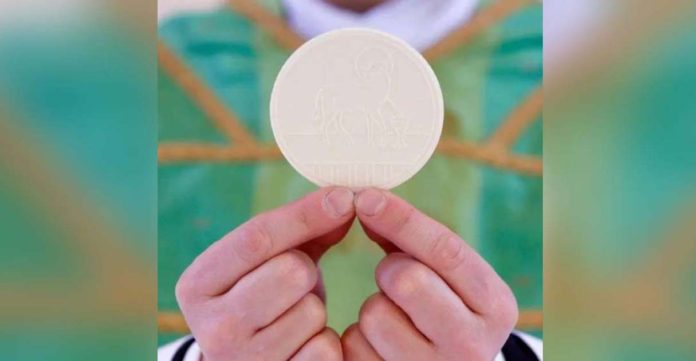 Ireland_superimposed A priest holds the Holy Communion by his fingertips. Also called the Eucharist, Holy Communion is a sacrament that commemorates the Last Supper. GETTY IMAGES