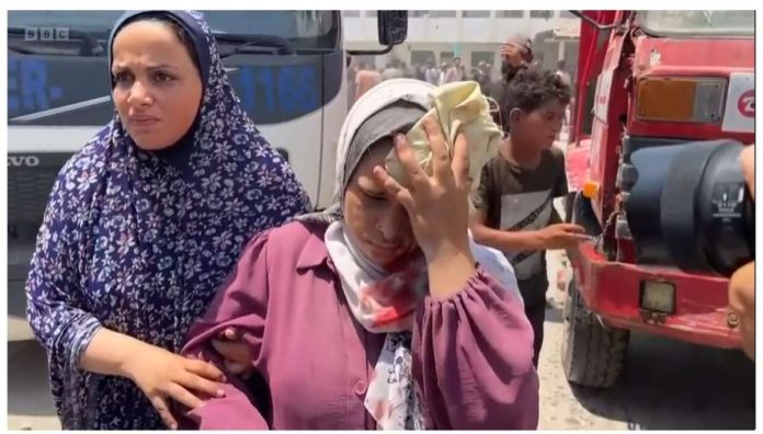 Israel_resized An injured Palestinian woman walks away covering her head after a school was bomb in the Gaza Strip. BBC