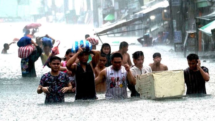 climate_resized Residents of Barangay Sto. Domingo, Quezon City head for a designated evacuation center as heavy rains triggered waist-deep floods on July 24, 2024. Metro Manila has been placed under a state of calamity due to massive flooding caused by continuous heavy rains brought by the Typhoon Carina-enhanced southwest monsoon. PNA