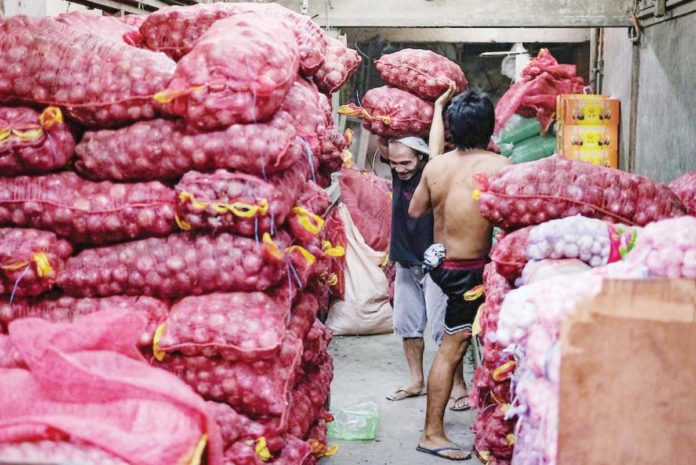 onions_resized_resized Workers unload bags of red onions inside a storage area in Divisoria market in Manila. GEORGE CALVELO, ABS-CBN NEWS/FILE PHOTO