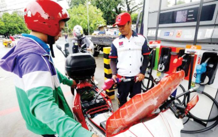 A gas station attendant fills up a motorcycle fuel tank in Paco, Manila on Monday, July 29. Local pump prices are set to decrease by less than P1 today. PNA PHOTO BY YANCY LIM