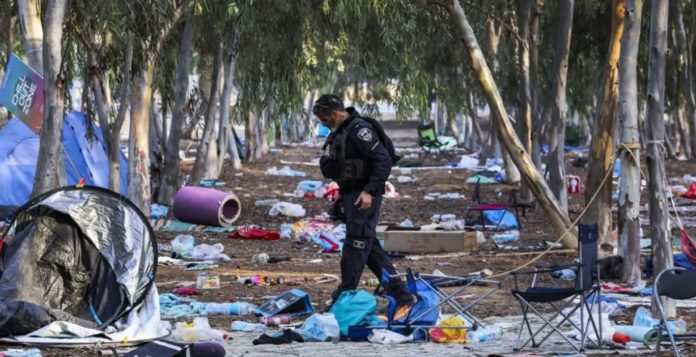 UN An Israeli officer walks through the wreckage of the Supernova music festival, in Israel, after the killing of hundreds of Israeli civilians by Hamas-led gunman on Oct. 7, 2023. EPA