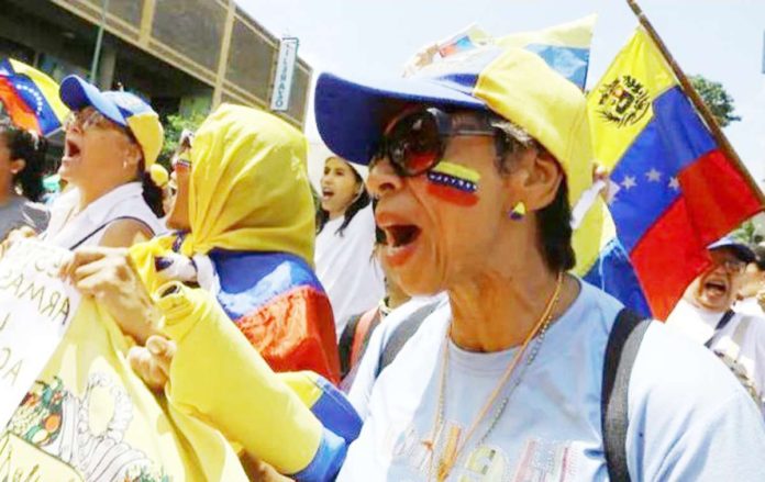 Venezuela_1_resized Women protests during a march in Venezuela. Demonstrations have been held across the country and in cities around the world over questionable election results. REUTERS