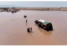 Yemen flooding leaves at least 57 dead People stand next to an overturned vehicle in flood waters in Yemen. REUTERS