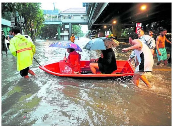 flood_resized Two boat riders choose the dry route as people around them wade through floodwaters on Taft Avenue, Manila, at the height of heavy rains last week due to super typhoon “Carina” and the southwest monsoon. MARIANNE BERMUDEZ, PHILIPPINE DAILY INQUIRER