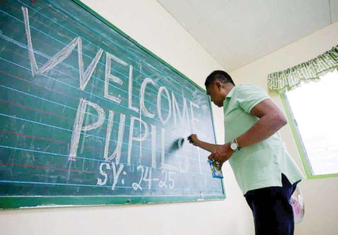 teachers_resized A teacher writes a welcome note at Wakas Elementary School in Kawit, Cavite. The Department of Education announced that public school teachers’ medical allowance will increase to P7,000 starting 2025. INQUIRER PHOTO / RICHARD A. REYES