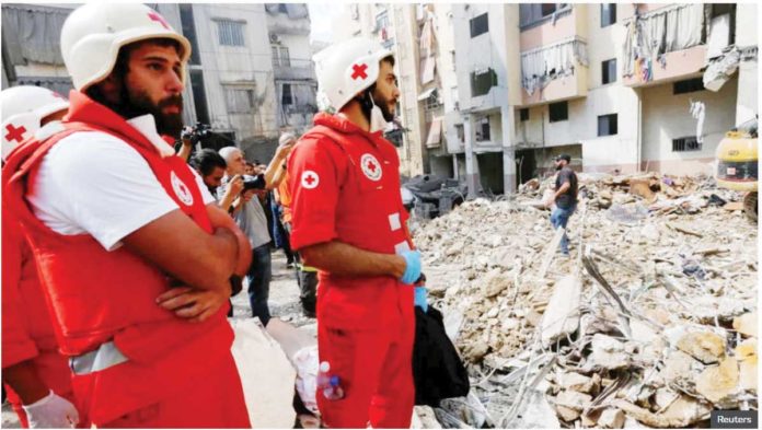 Lebanese medical personnel work at the site of Israeli strike, as search and rescue operations continue.