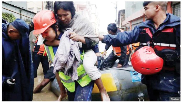 Nepal_1_resized A police personnel carries an injured woman from an inflatable raft after being rescued from a flooded area near the bank of the overflowing Bagmati River in Kathmandu, Nepal. REUTERS