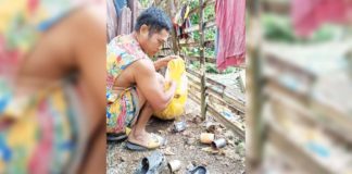 A resident of Barangay Codiong, Libertad, Antique eliminates mosquito breeding sites such as empty tin cans. BARANGAY CODIONG, LIBERTAD/FACEBOOK PHOTO