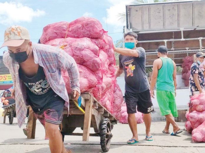 front_pic_resized The current minimum daily wage rates in Western Visayas are P480 for non-agricultural sectors employing more than 10 workers, P450 for those employing 10 or fewer, and P440 for workers in agriculture. Photo shows porters unloading agricultural products at the Iloilo Terminal Market in Iloilo City. PN FILE PHOTO