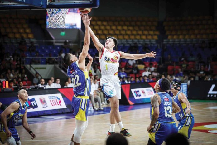 sports-Rain Rain or Shine Elasto Painters’ Adrian Nocum scores against the defense of Magnolia Chicken Timplados Hotshots’ Zavier Lucero. PBA PHOTO