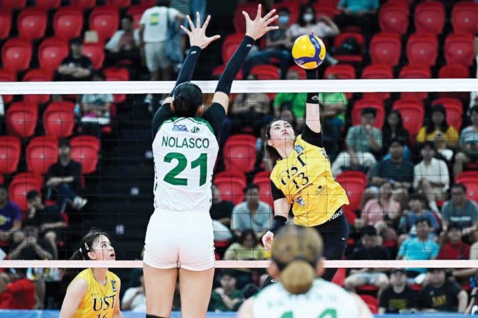 sports_UST_resized University of Santo Tomas Golden Tigresses’ Jonna Perdido scores against the defense of College of St. Benilde Lady Blazers’ Samantha Nolasco. PHOTO COURTESY OF V-LEAGUE
