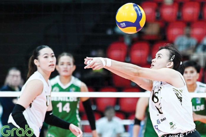sports_UST_resized Negrense Cassie Carballo of University of Santo Tomas Golden Tigresses tosses the ball as her teammate Pia Abbu looks on. PHOTO COURTESY OF V-LEAGUE