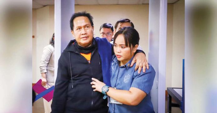 DFA-1_superimposed Pastor Apollo Quiboloy of the Kingdom of Jesus Christ is being escorted by a policewoman into the Senate to attend the Committee on Women’s hearing, his first since the body started its investigation in December 2023. PHOTO FROM SENATE PRIB