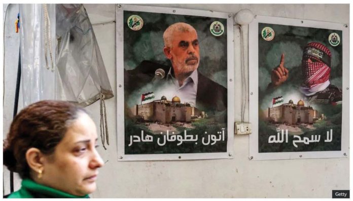 Israel_1_resized A woman walks past posters depicting Yahya Sinwar (left) in the Gaza Strip. Sinwar was the leader of Hamas. GETTY IMAGES