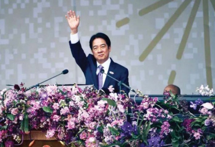 William Lai, in a suit, waves towards the crowd while on stage. He has adopted a more strident tone on China than his predecessor. GETTY IMAGES