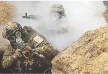 UK sanctions Russian troops over chemical weapons use in Ukraine Two Ukrainian soldiers moving through a trench during a chemical weapons training drill. They both have gas masks on and one is partially-obscured by smoke. REUTERS