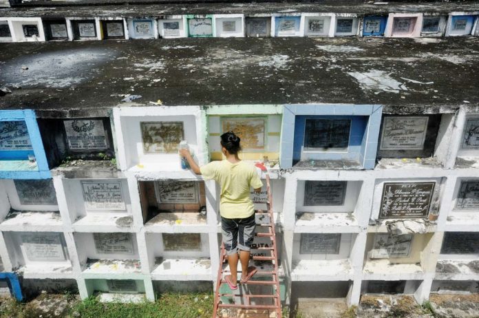 jaro REMEMBERING DEPARTED LOVED ONES. It is a tradition for families to visit cemeteries on Nov. 1 and Nov. 2, bringing candles and flowers for their departed loved ones. Photo shows a man sprucing up tombs at the Jaro Catholic Cemetery in Iloilo City ahead of Fiesta Minatay. AJ PALCULLO/PN