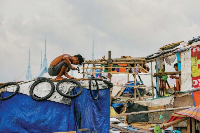 poor_1_resized A resident uses plastic sacks and scrap wood as he strengthens a shanty to help make it withstand the storms in Baseco Community in Tondo, Manila. JONATHAN CELLONA/ABS-CBN NEWS FILE PHOTO