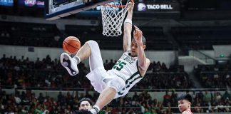 De La Salle University Green Archers’ Michael Phillips hangs into the ring after a slam dunk. UAAP PHOTO