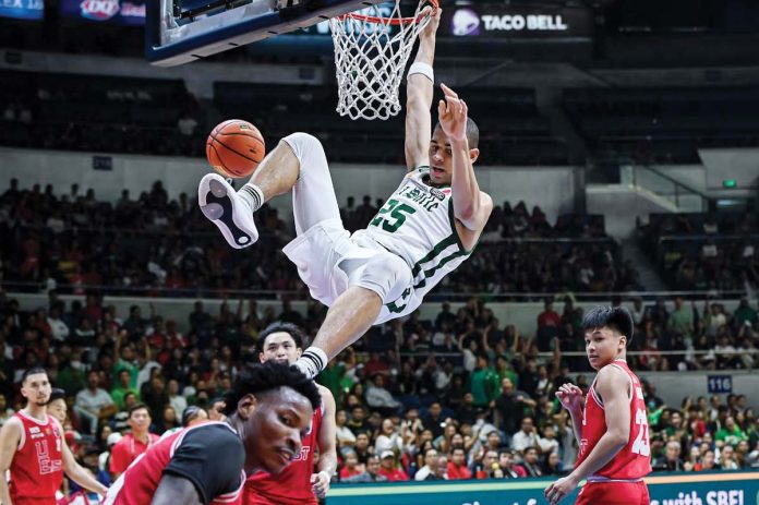De La Salle University Green Archers’ Michael Phillips hangs into the ring after a slam dunk. UAAP PHOTO
