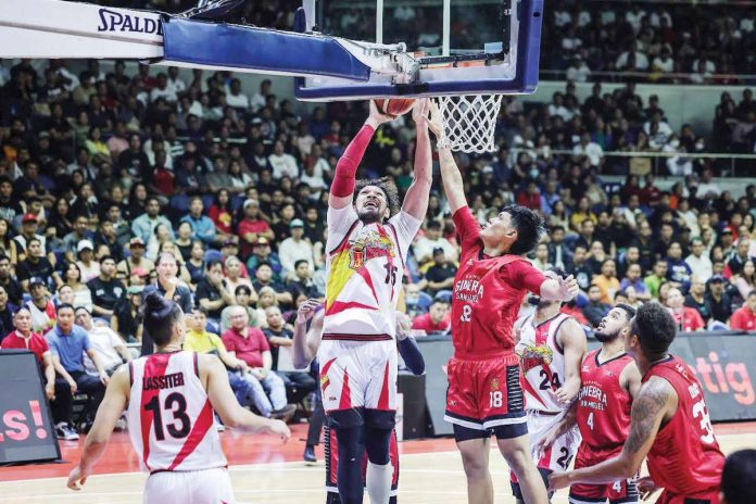 sports_San_resized San Miguel Beermen’s June Mar Fajardo scores against the defense of Barangay Ginebra San Miguel Kings’ Ralph Cu. PBA PHOTO