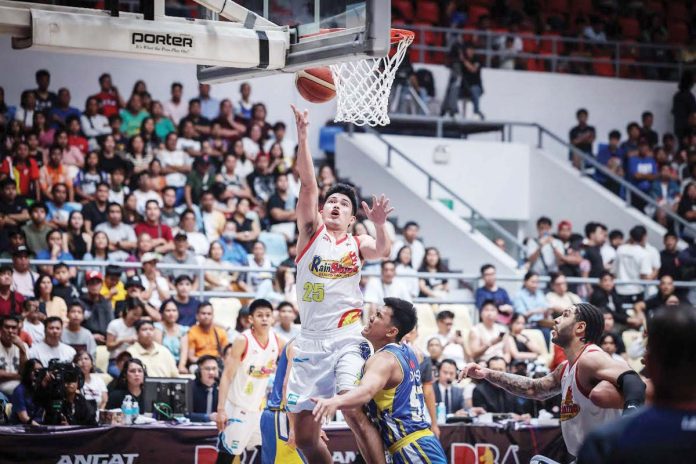sports_rain_resized_resized Rain or Shine Elasto Painters’ Leonard Santilaln attacks the defense of Magnolia Chicken Timplados Hotshots’ Aris Dionisio for an inside hit. PBA PHOTO