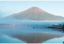 Snow back on Mount Fuji after longest absence A wide shot of Mount Fuji seen without snow, silhouetted in a blue lake, in September last year. GETTY IMAGES