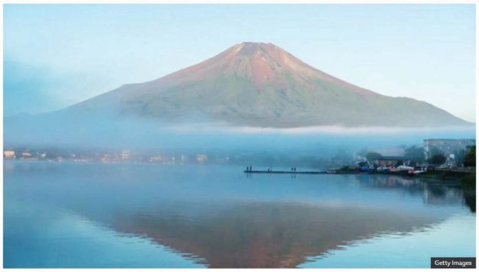 Japan_1_resized A wide shot of Mount Fuji seen without snow, silhouetted in a blue lake, in September last year. GETTY IMAGES