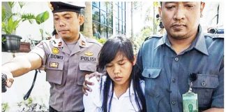 This 2015 photo shows a handcuffed Mary Jane Veloso being escorted by two Indonesian policemen. She faced drug charges. PHOTO FROM WIC.ORG