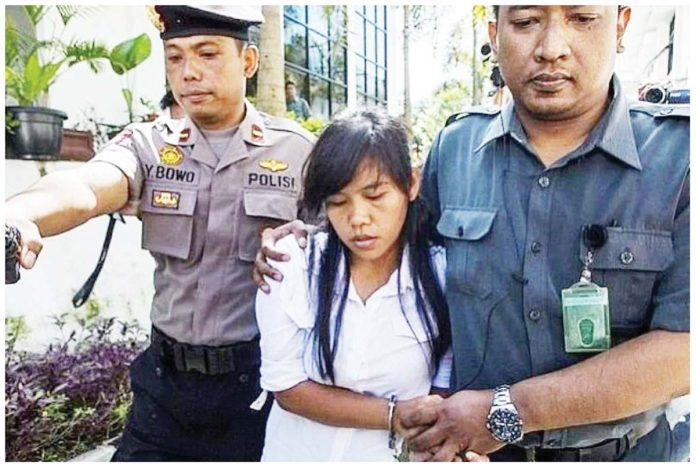 PH-1 This 2015 photo shows a handcuffed Mary Jane Veloso being escorted by two Indonesian policemen. She faced drug charges. PHOTO FROM WIC.ORG