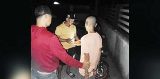 Officers of the Pavia Municipal Police Station led by Major Harold Rendora serve the arrest warrant for robbery with violence against or intimidation of persons, or Revised Penal Code Article 294, against Ronald Arguilles Fajardo (right) in San Jose City, Nueva Ecija on Oct. 31, 2024. PAVIA MUNICIPAL POLICE STATION PHOTO