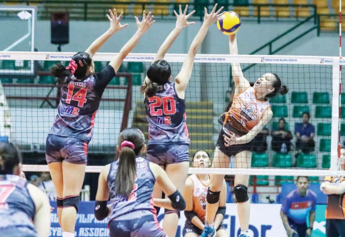 sports_Quezon_1_resized Quezon Tangerines’ Mary Grace Borromeo smashes the ball against two Biñan Tatak Gel 1-Pacman Partylist Volley Angels’ defenders. MPVA PHOTO