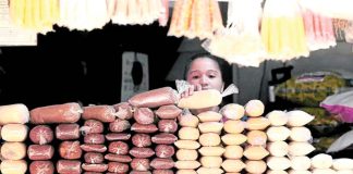 A woman stacks sugar at a store in Manila. INQUIRER/ MARIANNE BERMUDEZ