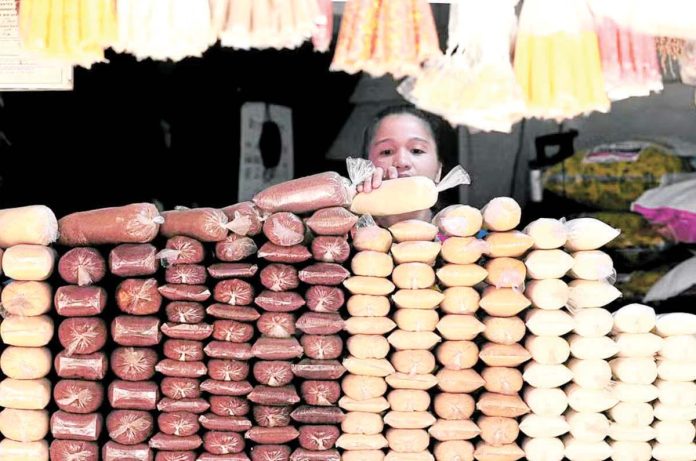 SRA_sugar_resized A woman stacks sugar at a store in Manila. INQUIRER/ MARIANNE BERMUDEZ