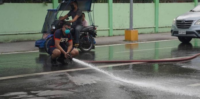 ashfall-cleaning Bago City Fire Station personnel are currently cleaning the city's main streets affected by the ash fall from Mount Kanlaon's eruption yesterday afternoon, December 9. Photo courtesy of The Citybridge