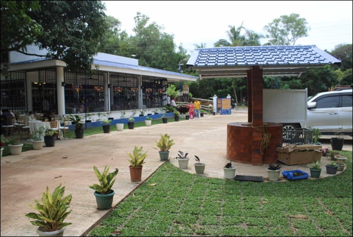 Photo shows UMA Restaurant by KokoMojo Farm, featuring a wishing well in front, and a spacious parking lot for tourists.