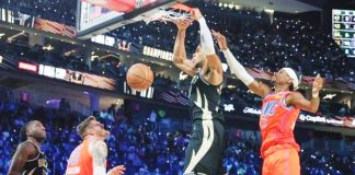 Giannis Antetokounmpo of Milwaukee Bucks dunks ahead of Shai Gilgeous-Alexander of Oklahoma City Thunder. GETTY IMAGES