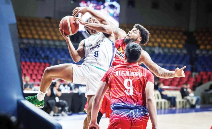 sports_PBA_1_resized Converge FiberXers’ Deschon Winston is clobbered by the defense of Phoenix Fuel Masters’ Donovan Smith as he goes for an inside hit. PBA PHOTO