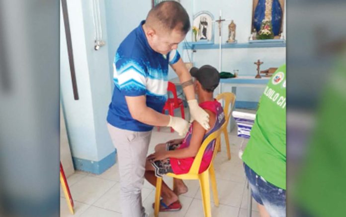 vax-drive A city health worker administers the influenza vaccine to a city resident in this undated photo. The Iloilo City Government is encouraging everyone to avail of the free vaccine for their protection. CHO PHOTO