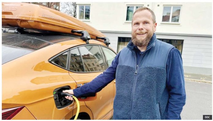 Norway_1_resized_resized Norwegian motorist Ståle Fyen smiles as he attaches a charging cable to his electric car. Like a third of Norwegian motorists, Fyen now drives an electric car. BBC