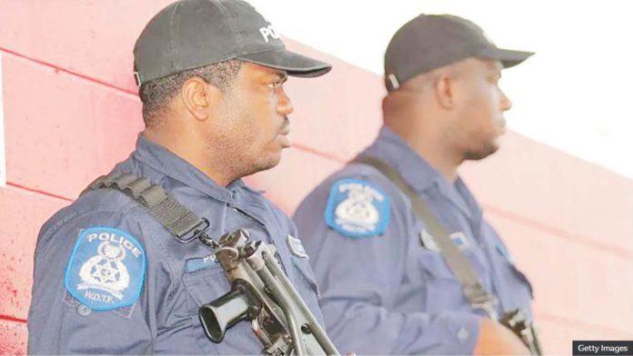 Trinidad_1_resized Two armed policemen in Port of Spain, Trinidad, seen in profile wearing black baseball caps and blue shirts. GETTY IMAGES