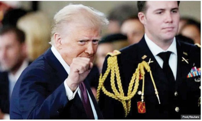US US President Donald Trump gestures with a clenched fist, in front of a member of the US military, during his inauguration ceremony. Pool/Reuters